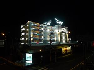 横浜市にあるホテルゴルフ保土ヶ谷（大人専用）の夜間ネオンの看板が立つ建物