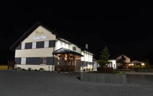 a white building with a sign on it at night at Rajska Oaza in Przybradz