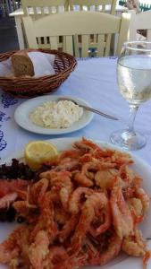 a plate of shrimp and rice and a glass of water at Апартаменты Вилла Ионика in Kalón Nerón