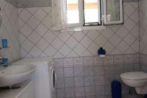 a bathroom with a sink and a washing machine at Апартаменты Вилла Ионика in Kalón Nerón