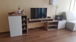 a tv sitting on a stand in a living room at Апартамент за нощувки in Gotse Delchev