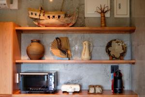 a shelf with a microwave and other items on it at Kaiza in Nanjo