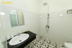 a white bathroom with a sink and a mirror at An Phu Hotel Da Lat in Da Lat