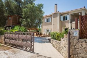 a villa with a gate in front of a house at Julia's Villa style Apartment in Kástron