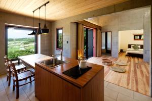 a kitchen and living room with a sink and a table at Kaiza in Nanjo