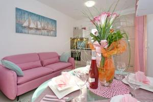 salon z fioletową kanapą i stołem z kwiatami w obiekcie Villa Nivel w mieście Vir
