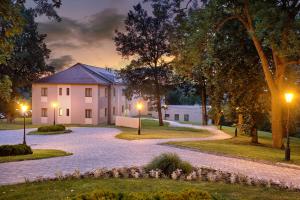 ein Haus in der Nacht mit Lichtern an einer Auffahrt in der Unterkunft La Contessa Castle Hotel in Szilvásvárad