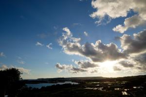 a view of the sky with the sun hiding behind clouds at Kaiza in Nanjo