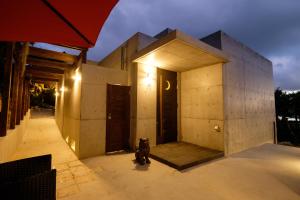 a black dog sitting in front of a building at Kaiza in Nanjo