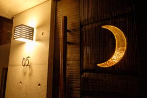 a lit up letter c on a wall with a light at Kaiza in Nanjo