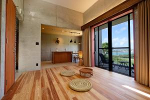 a living room with a floor to ceiling glass window at Kaiza in Nanjo