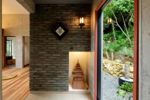 a brick wall with a light in a hallway at Kaiza in Nanjo