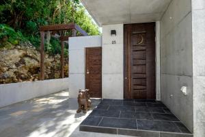 a dog standing in front of a door at Kaiza in Nanjo