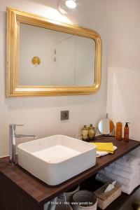 uma casa de banho com um lavatório branco e um espelho. em Broel4 em Kortrijk