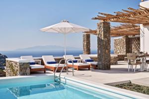 a villa with a swimming pool and an umbrella at Katikies Villas Mykonos in Elia Beach