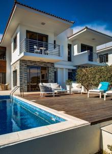 a house with a swimming pool in front of a house at Atlantis Gardens in Mazotos