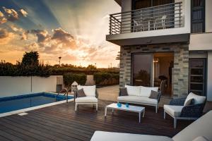 a patio of a house with a pool at Atlantis Gardens in Mazotos