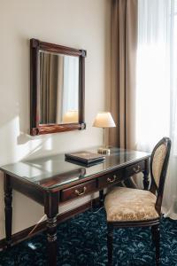 a desk with a mirror and a lamp and a chair at Sun Hotel in Irkutsk
