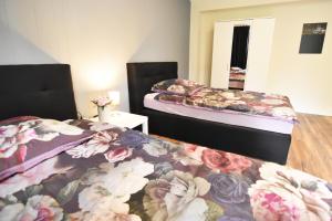 2 Betten in einem Zimmer mit Blumen in der Unterkunft Dorya am Ring in Köln