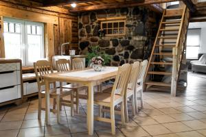 a dining room with a wooden table and chairs at Erlendi Kodumajutus in Pärnu