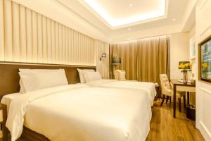 ein Hotelzimmer mit 2 Betten und einem Schreibtisch in der Unterkunft Polysheron Hotel Changsha Houjiatang Metro Station Branch in Changsha