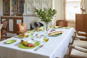 una mesa con un mantel blanco con comida. en Bella Ev Guest House, en Muizenberg