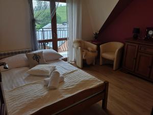 Mizerna的住宿－Pokoje Goscinne Pieninska Parzenica，卧室配有床、椅子和窗户。