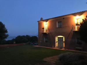 ein Haus mit einer beleuchteten Tür und einem Hof in der Unterkunft Monti di Jogliu in Arzachena
