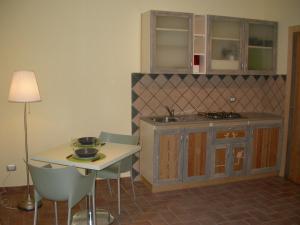 una cucina con lavandino e tavolo con sedie di Casavacanze Sant'Eugenia ad Attigliano