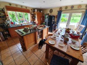 a kitchen with a wooden table and a dining room at Whitehead Bed and Breakfast in Whitehead