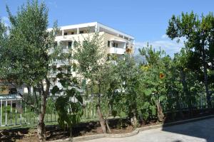 un edificio bianco con alberi di fronte a una recinzione di Sunflower a Spalato (Split)