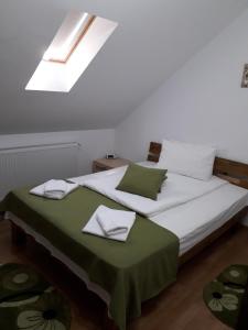 um quarto com uma cama grande e um cobertor verde em Mary Apartment em Sibiu