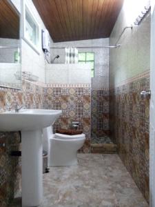 Hotel Khaosok and Spa في خاو سوك: حمام مع حوض ومرحاض ودش