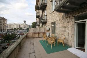 Un patio con una mesa y sillas en un balcón. en Inn Home Apartments in Kiev Center, en Kiev