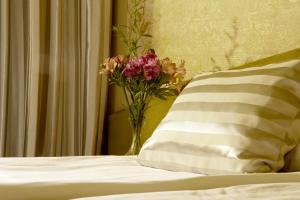 a vase of flowers sitting on top of a bed at Triada Hotel in Sofia