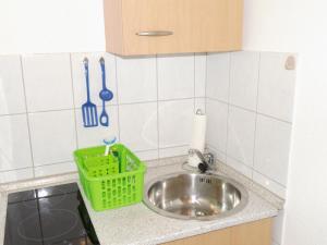 a kitchen sink with a green basket next to it at Ferienwohnung am Rennsteig bei Eisenach - Ilona Schmidt in Wolfsburg-Unkeroda