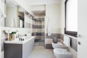 La salle de bains blanche est pourvue d'un lavabo et de toilettes. dans l'établissement Opera Residence, à Bologne