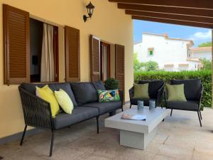 a patio with a couch and a coffee table at Casa Coromines in Alcudia