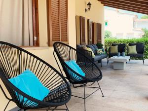 two chairs with blue pillows sitting on a patio at Casa Coromines in Alcudia