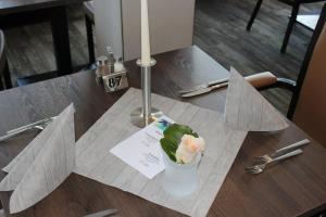 une table avec un vase et des fleurs sur lui dans l'établissement Inselhotel Rote Erde, à Borkum