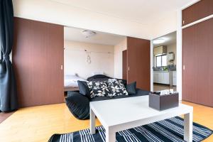 uma sala de estar com uma cama e uma mesa branca em Murata Corpo 301 em Tóquio