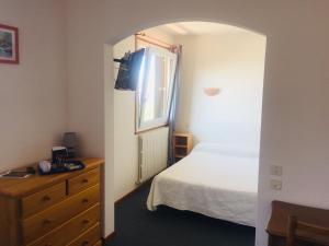 a bedroom with a bed and a dresser and a window at La bagatelle in Saint-Michel-de-Chaillol