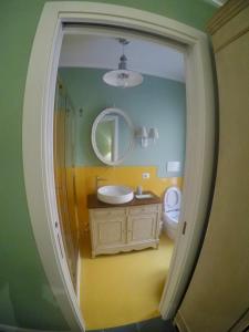 a bathroom with a sink and a mirror and a toilet at Le Stanze del Borgo in Nettuno