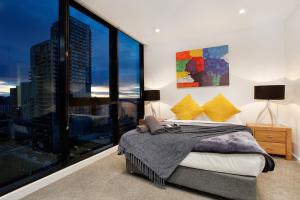a bedroom with a bed and a large window at StayCentral on Lonsdale in Melbourne