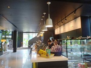 a group of people sitting at a counter in a restaurant at TK Palace Hotel & Convention in Bangkok