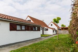 a row of white houses with red roofs at Zeegalm Bungalows in Middelkerke