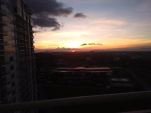 a sunset seen from the window of a building at Rm Staycation City View SMDC in Kaybagal +10 photos
