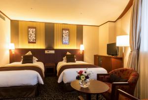 a hotel room with two beds and a table at Shibuya Creston Hotel in Tokyo