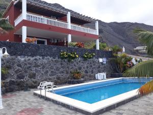 uma villa com piscina em frente a uma casa em Complejo Solymar em Puerto Naos