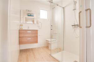 uma casa de banho com um WC e uma cabina de duche em vidro. em Apartamentos Hotel Pirineos em Figueres